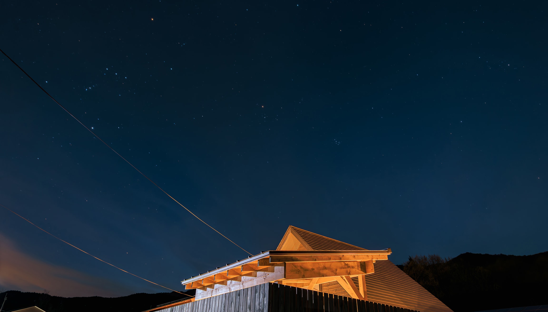 夜空に星が輝き、灯りに照らされたヴィラの屋根